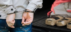 A drug trafficker arrested next to drugs