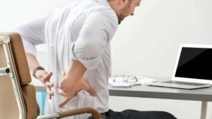 A man winces over back pain