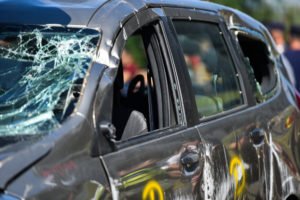 A black car sits damaged after an accident