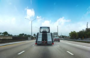 A car transporter driving on a Florida highway.
