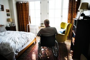 A man sits alone in a wheelchair