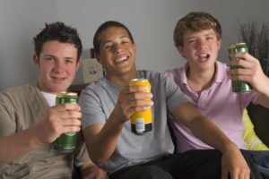Teenagers holding beer cans