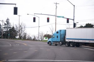 A tractor-trailer driving through an intersection