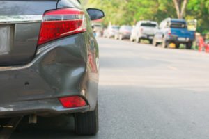 A car with damage to its rear bumper.