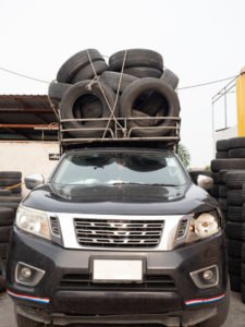 A truck with loose tires on its roof.