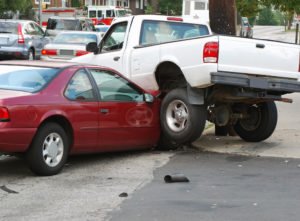 A white truck after its collision with a red car