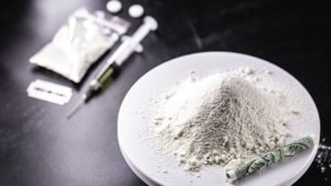 pile of cocaine with rolled-up dollar bill