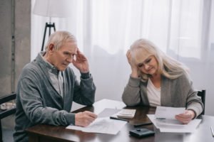 A stressed, senior couple looking at bills.
