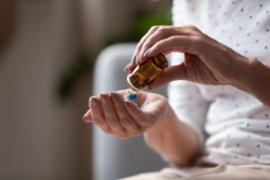 woman pouring pills into her hand