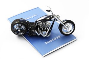 mini motorcycle sitting on an insurance folder