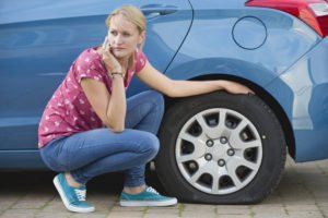 woman with flat tire calling for help