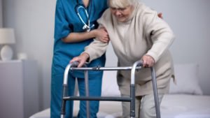 nurse assists a senior patient with hip pain