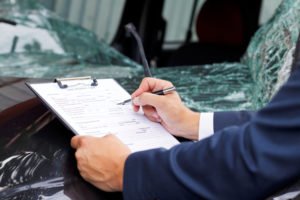 insurance adjuster examins vehicle damage