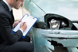 insurance adjuster exams car wreck damage
