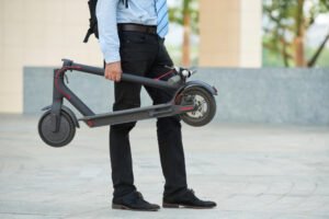 business man holding electric scooter